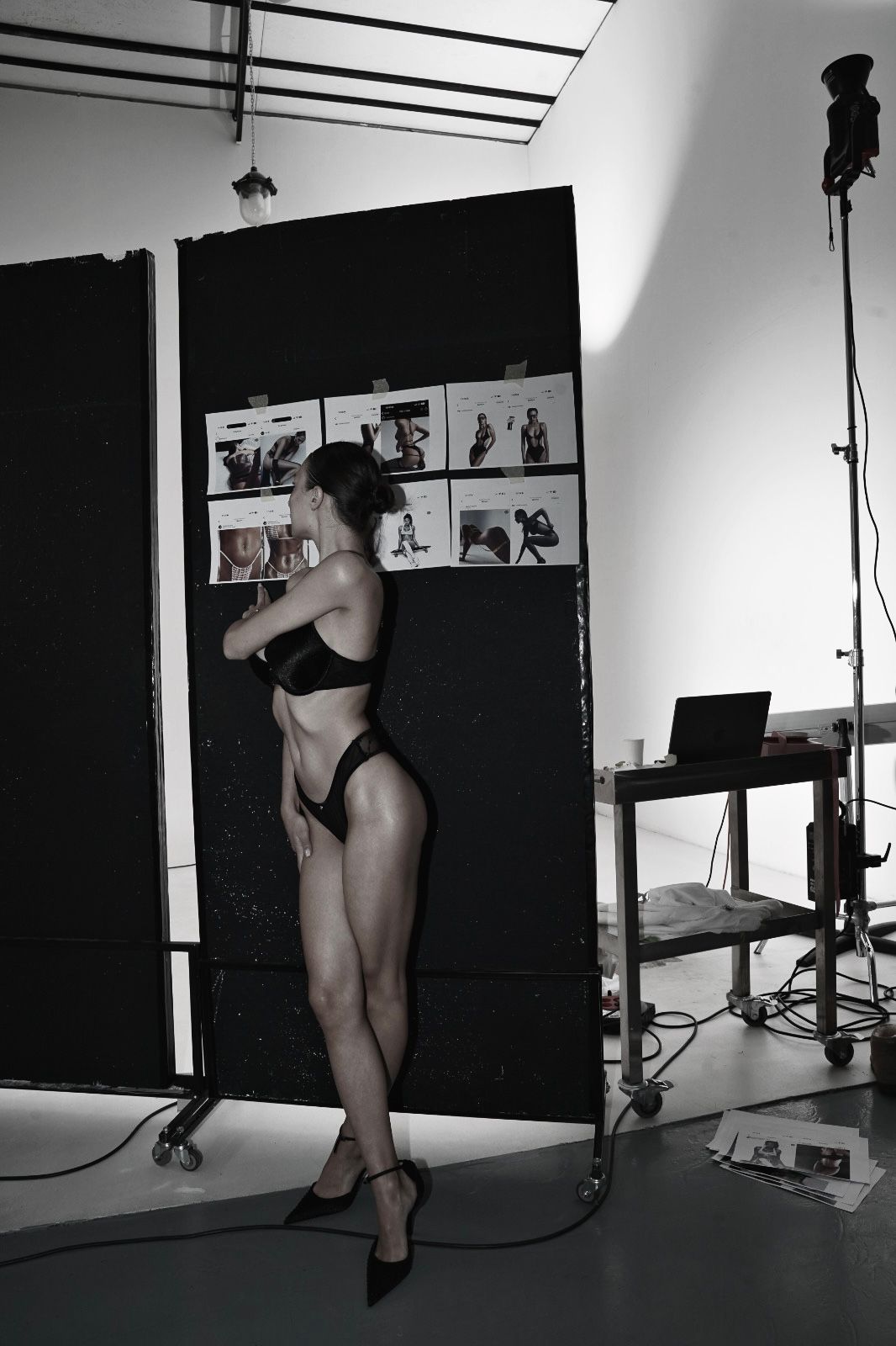 Modèle en lingerie noire Silwete, debout face à un mur de créations, capture d’un moment suspendu entre puissance du corps et préparation éditoriale.